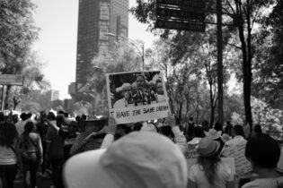 a picture from the civil rights movement. Lots of people gathering holding signs. 