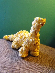 A picture of a dinsosaur created out of popcorn. 