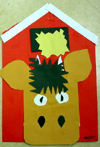 A picture of a cow and barn craft. Shows a cows head pasted to a red barn. 