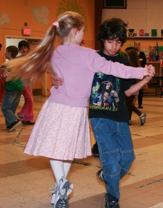 A picture of a young girl and boy line dancing. 