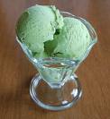 A picture of green ice cream scoops in a glass service dish. 