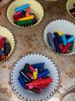 A picture of broken pieces of crayon in a muffin pan liner. 