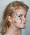 A young girl with stars and other objects painted on her face. Sideview. 