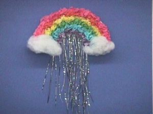 A picture of the rainbow, clouds, rain craft. It looks like a rainbow with clouds at each end and rain coming down. 