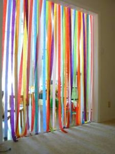 A picture of a doorway decorated with different colored streamers. You have to walk through the rainbow colored streamers to transition from room to room. 