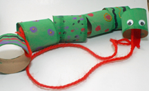 A picture of a snake made from paper towel tubes wrapped in green construction paper. The snake has googly eyes and a red yarn string for a tongue. 