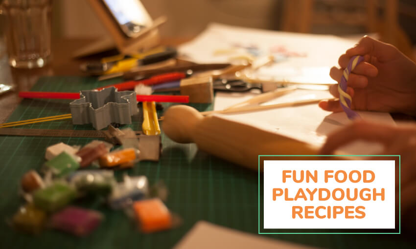 An image of someone decorating playdough. There's a rolling pin and cookie cutters laid out on the table. Text reading fun food playdough recipes for kids. 