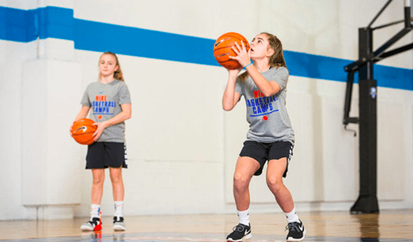 a girl throwing a free throw with a basketball on the field