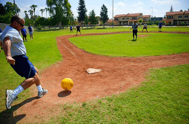 a group of people playing kick ball