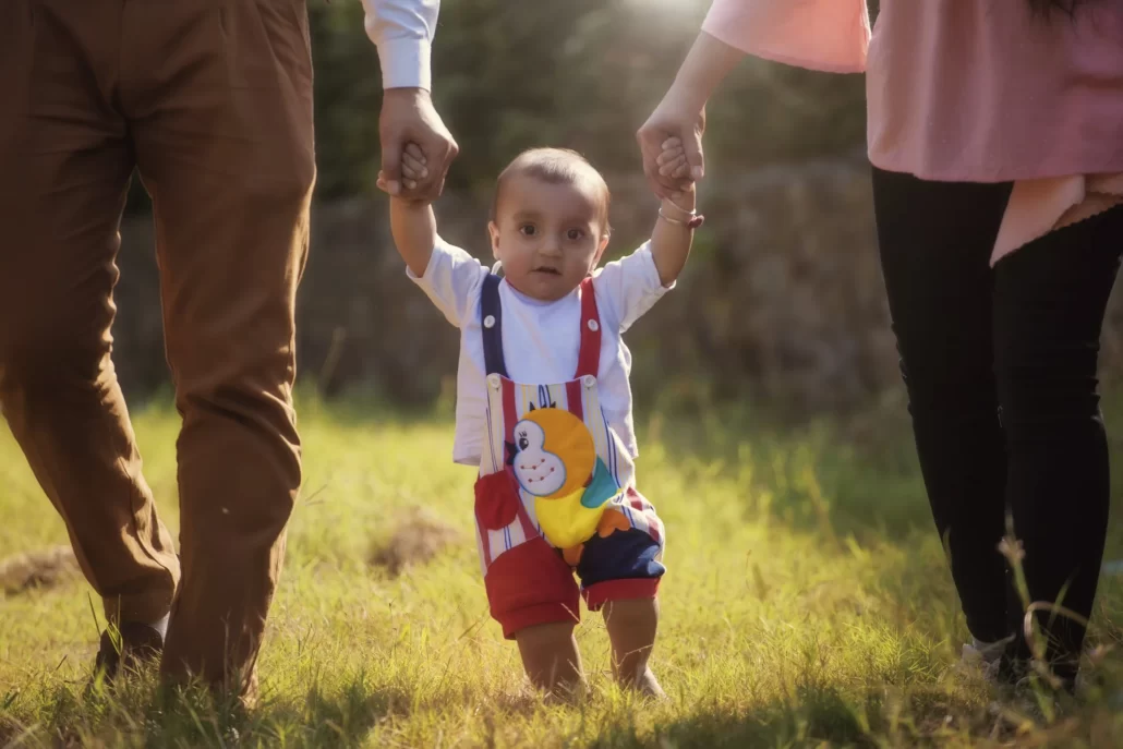 baby walking with two adults