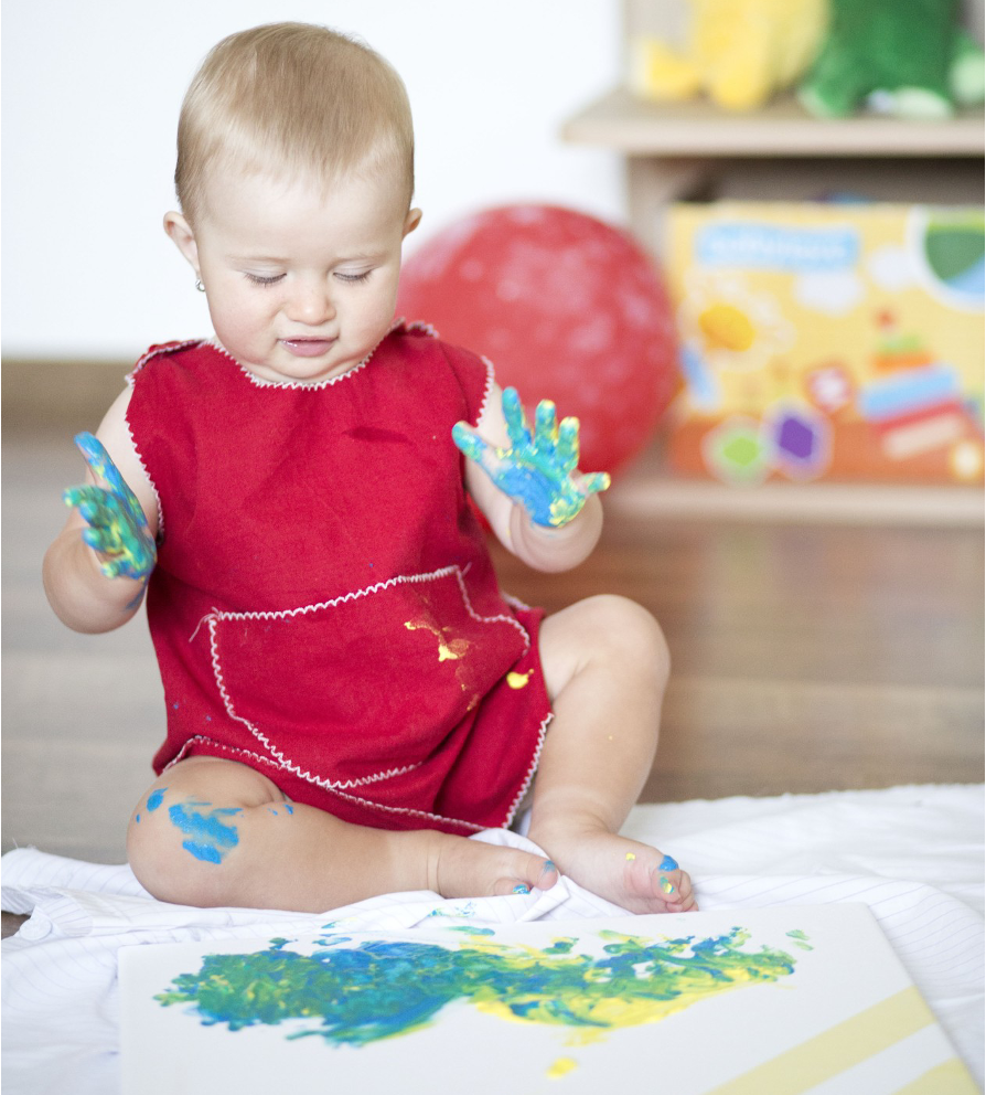 baby with his palms painted with color