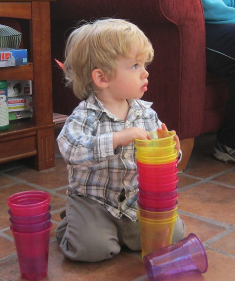 baby stacking up empty plastic cups