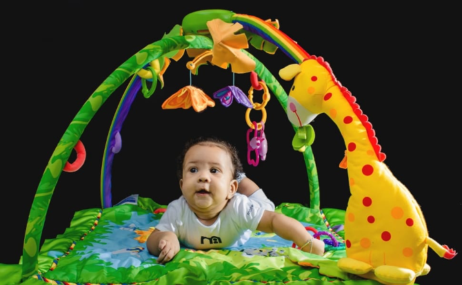 baby laying down on a play gym