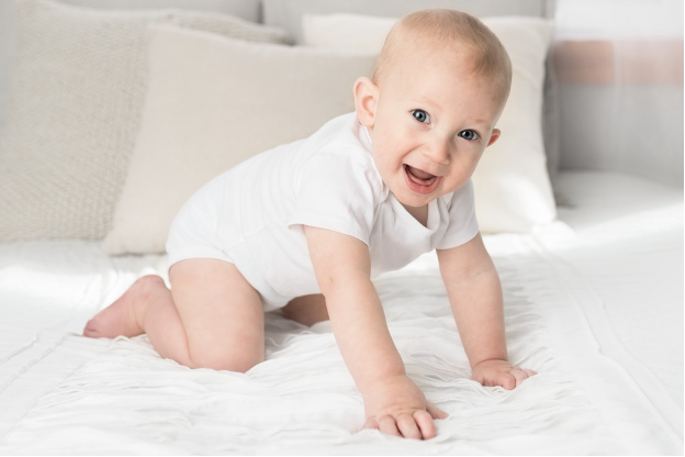 baby crawling on a bed