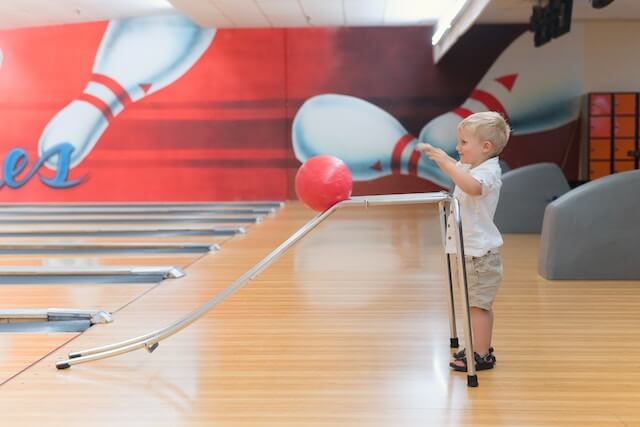kid pushing a bowling ball
